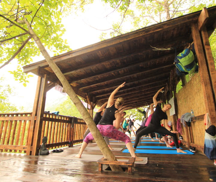 People on a yoga holiday in Montenegro participating in a yoga workshop outside on a wooden deck at Villa Miela near Lake Skadar