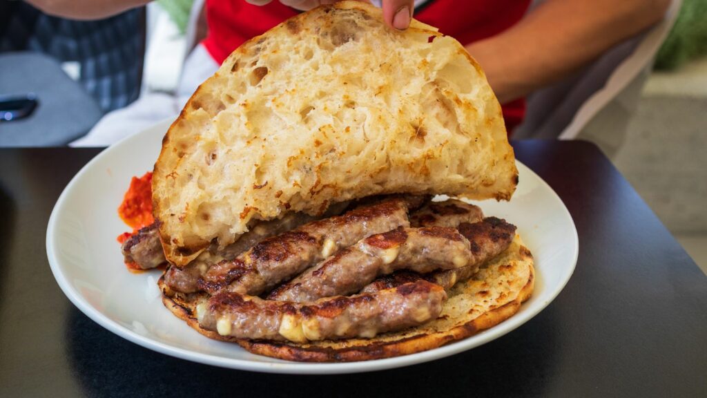 Cevapi served in a pitta bread. Cevapi is a Balkan sausage. It's a great BBQ recipe.