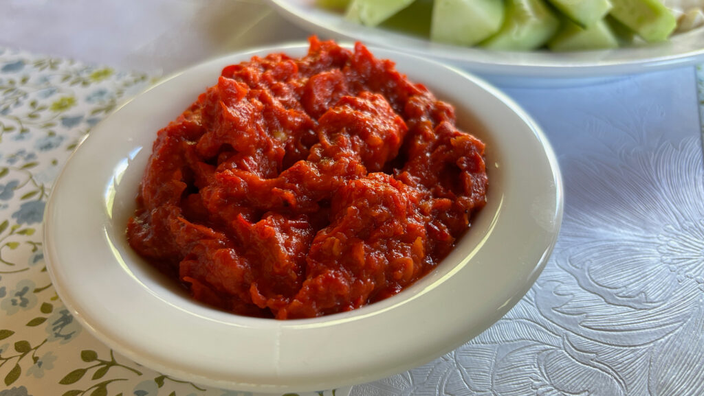 A white bowl full of ajvar, a red pepper sauce from the Balkans