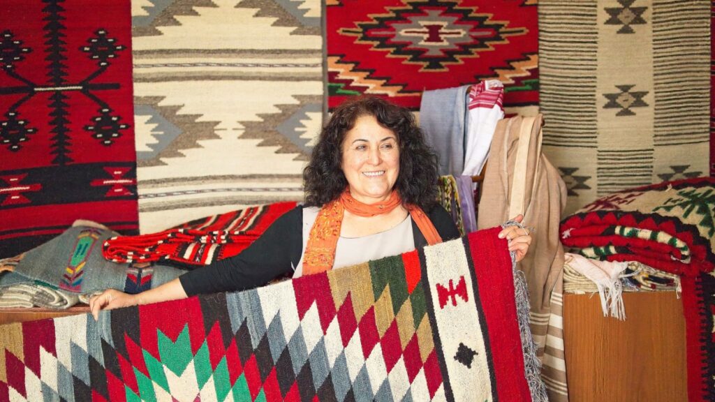 Nebija Qotaj showing us her rugs